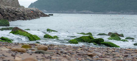 water come in to the sea across the stonesの写真素材