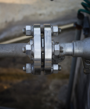 Close up  steel pipe flange connected by tighten bolt ands nuts