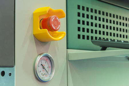 Emergency stop button and vacuum gage in machine