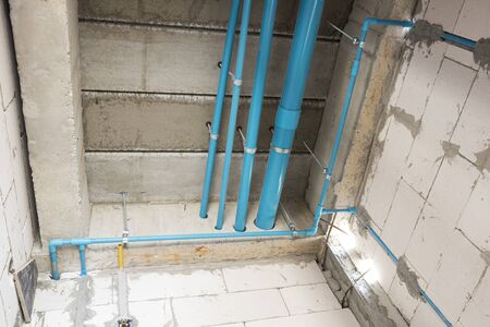 PVC tube  in water piping system and draining system installation under concrete floor in under construcion building ; industrial system backgroundの写真素材