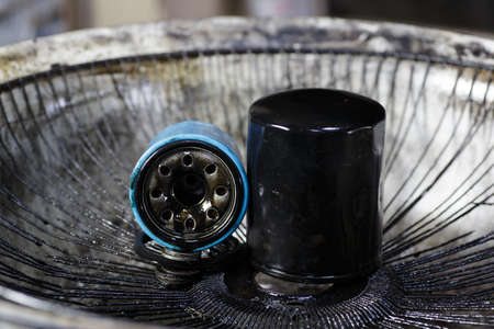 Car oil filter is very dirty and oil stains background.engine oil stain