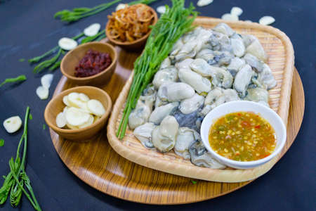 Oysters with acacia leaves Fried onions, fresh garlic, seafood sauce. Popular food of Asian people