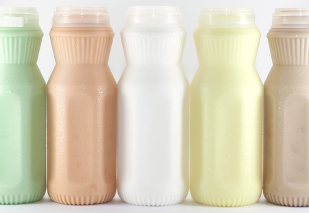 milk (melon,corn,tea and coffee taste) in a plastic bottle on a white backgroundの写真素材
