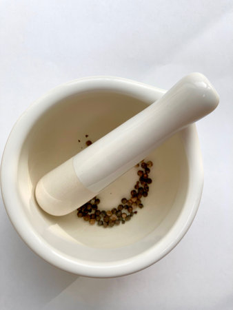 View into a white mortar on black pepper ballsの写真素材