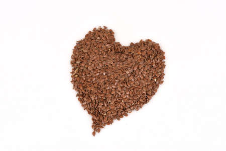 Flax seeds, dried seeds have medicinal properties and on a white background. (Placed in a heart shape)の写真素材