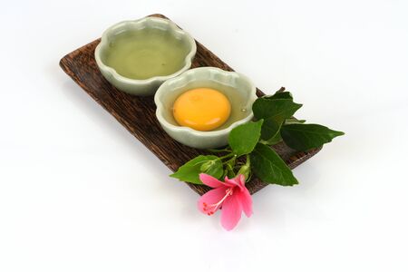 Egg yolks and egg whites in a cup have medicinal properties and placed on a white background.の写真素材