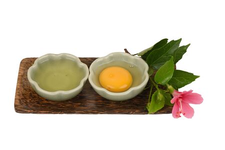 Egg yolks and egg whites in a cup have medicinal properties and placed on a white background.の写真素材