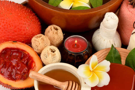 Face mask and soap with gac fruit extract and honey, spa treatment concept, medicinal properties on a white background.の写真素材