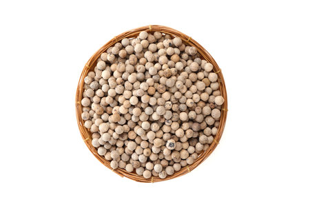 Dried white pepper in a bamboo basket isolated on whiteの写真素材