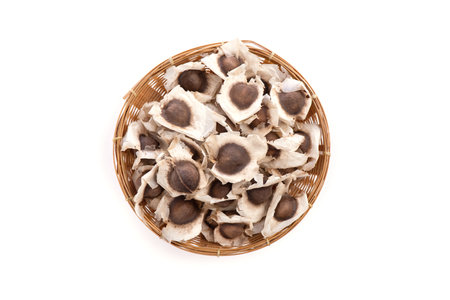 Dried Moringa seeds in a bamboo basket isolated on whiteの写真素材