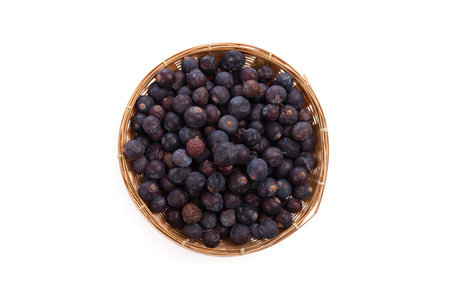 Dried Juniper Berry in a bamboo basket isolated on whiteの写真素材