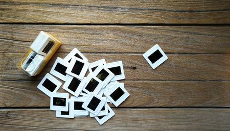 old 35mm slide film with box on wood background.の写真素材