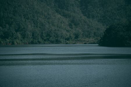 Lake and mountain background in thailand. Dark tone.