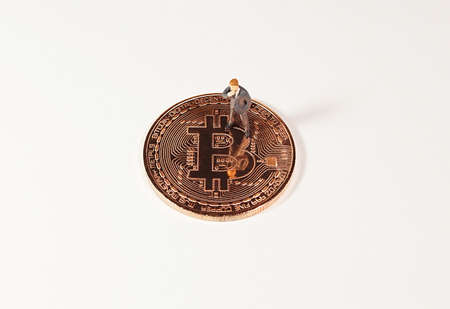 Business man figure standing on bitcoin. Bitcoin mining concept.