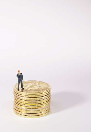 Business man figure standing on bitcoin. Bitcoin mining concept.の写真素材