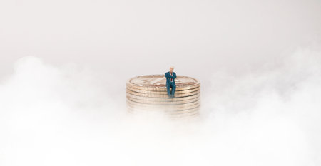 Business concept. Businessman sitting on a pile of silver coins.