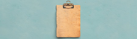 Blank wooden clipboard on a blue background.の素材