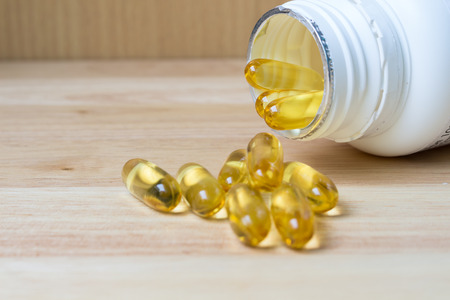 Evening primrose oil capsule on woodsupplementary foodの写真素材
