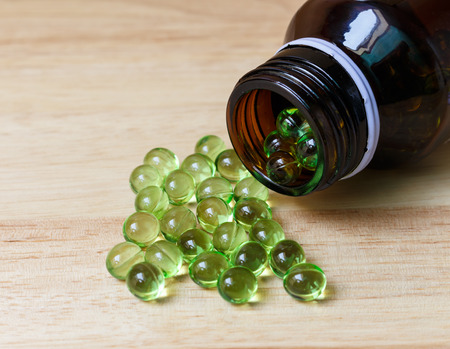 Supplement food,Vitamin E capsule on wooden table.の写真素材