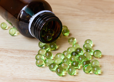 Supplement food,Vitamin E capsule on wooden table.の写真素材