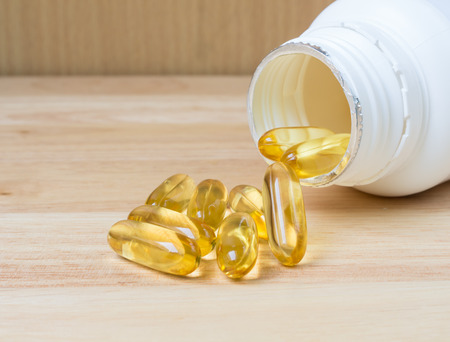 Evening primrose oil capsule on wood,supplementary foodの写真素材