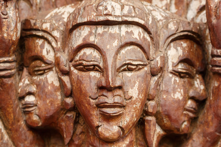 Buddha face,wood-carving of the old wooden door in Thai temple.の写真素材