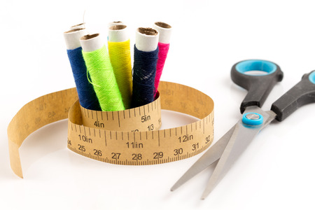 measuring tape with reel and scissor on white