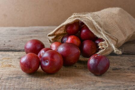 Gulf Ruby plum In a bag on a wooden tableの写真素材