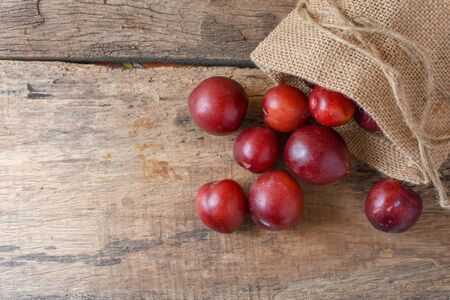 Gulf Ruby plum In a bag on a wooden tableの写真素材