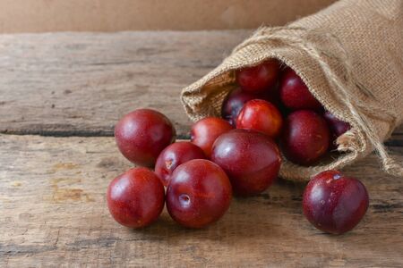 Gulf Ruby plum In a bag on a wooden tableの写真素材