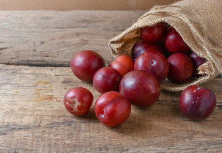 Gulf Ruby plum In a bag on a wooden tableの写真素材