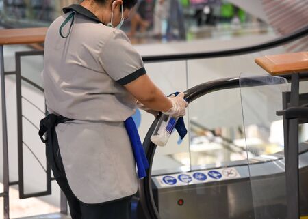 Staff are cleaning the escalator rail to prevent the virusの写真素材