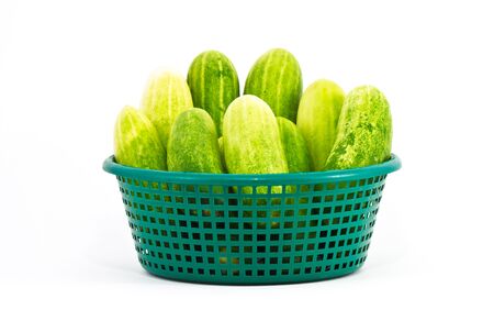 The green cucumbers in green basket on white backgroundの写真素材