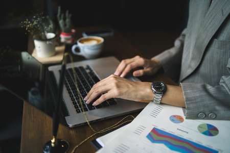 business person working with laptop computer by using hand typing a keyboard on office table desk,...