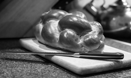 Braided bread with knife on cutting boardの写真素材