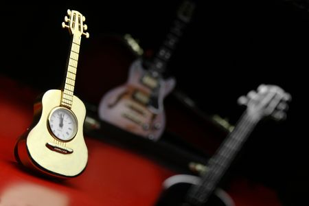 High-resolution image of a guitar shaped clock displaying 12 at Midnight.