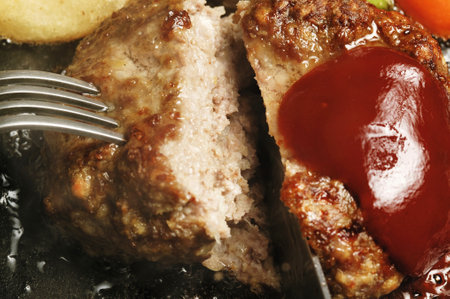 Meatloaf with sauce on a frying pan, close-up