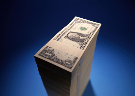 Stack of dollars on blue background. Shallow depth of field.の写真素材