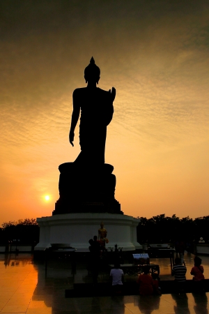 big buddha statue in silhouette with buddhists prayingの写真素材