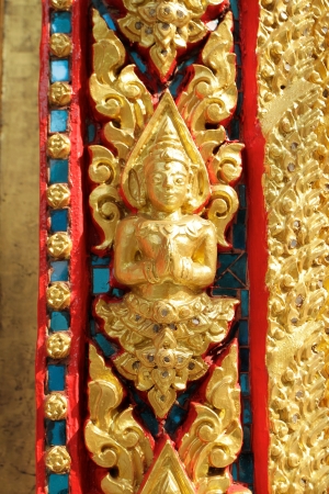 thai golden angel sculpture at temple gate in greeting postureの写真素材