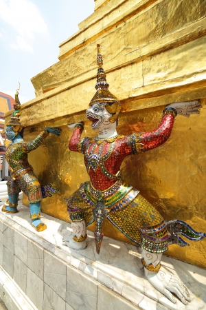 stucco statues of half monkey half angel and giant carrying golden chedi, thailandの写真素材
