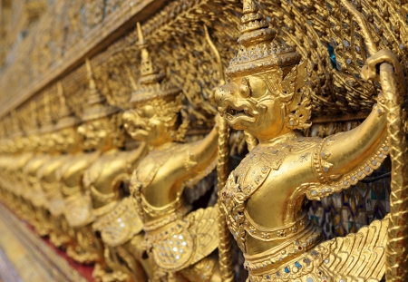 golden statues of garuda catching naga, wat pra kaew, thailandの写真素材