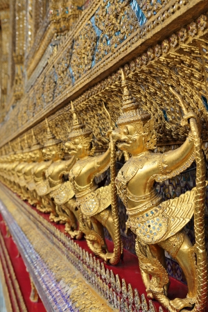 golden statues of garuda catching naga, wat pra kaew, thailandの写真素材