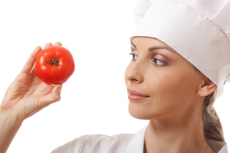 Smiling woman cook with red tomatoの写真素材