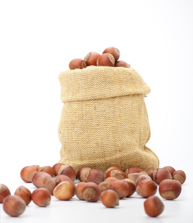 hazelnuts in a burlap bag on white backgroundの写真素材