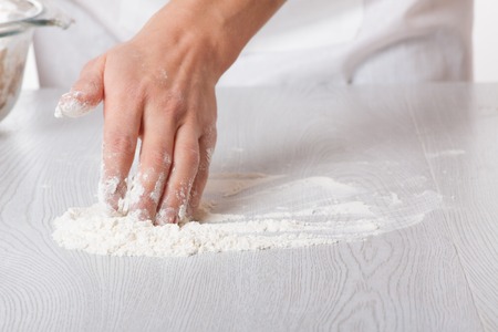 Hands and white wheat flourの写真素材