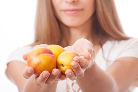 peaches in female hand, isolated on white の写真素材