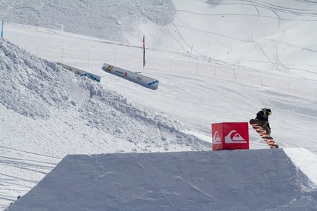 SOCHI, RUSSIA - MARCH 22, 2014: Snowboarder jumps in Snow Park,  mountain ski resort Rosa Khutor.