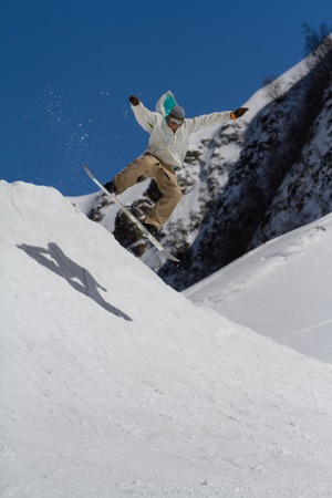 SOCHI, RUSSIA - MARCH 22, 2014: Snowboarder jumps in Snow Park,  mountain ski resort Rosa Khutor.のeditorial素材