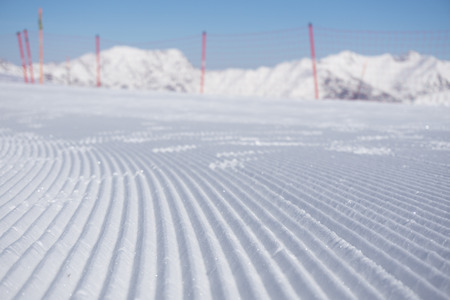 Fresh snow groomer tracks on a mountain ski pisteの写真素材